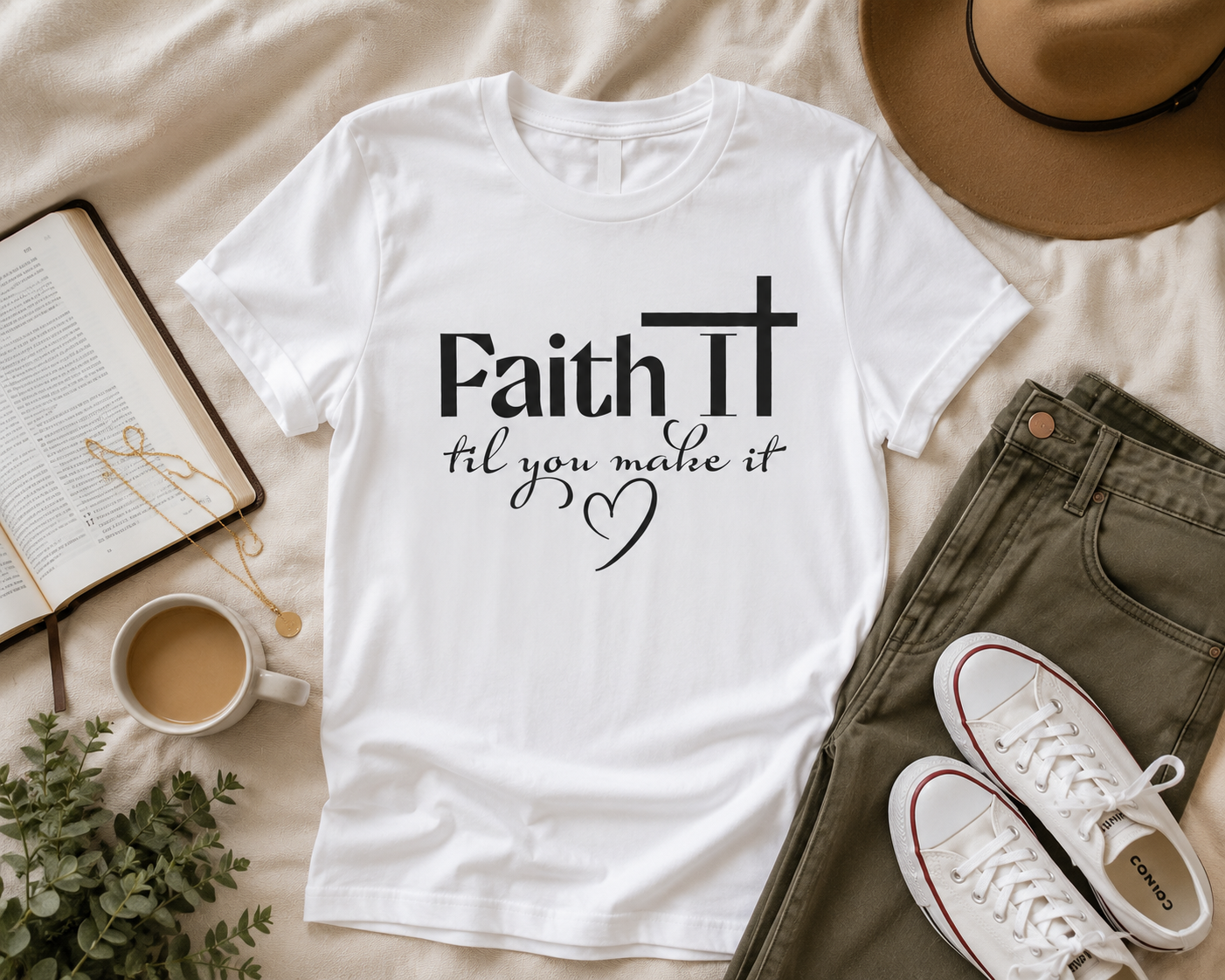 White “Faith It Til You Make It” Christian t-shirt flat lay with olive jeans, Bible, gold jewelry, coffee, and neutral modern lifestyle styling
